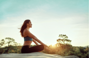 Happy and healthy woman practiving yoga on sunset outdoors meditation