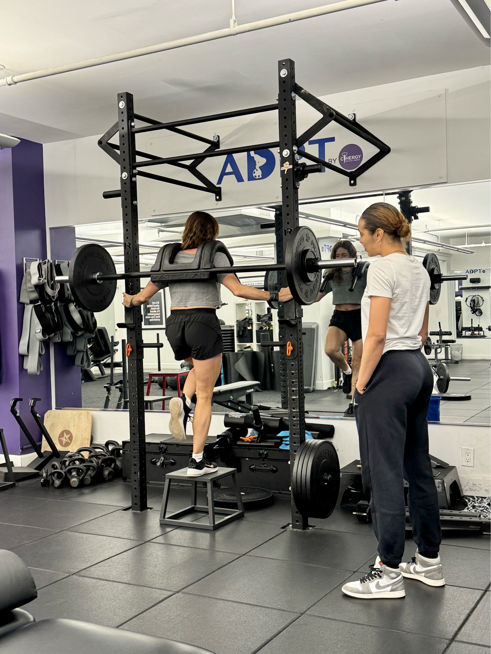 Sports physical therapist guiding high-performance client through injury prevention exercises