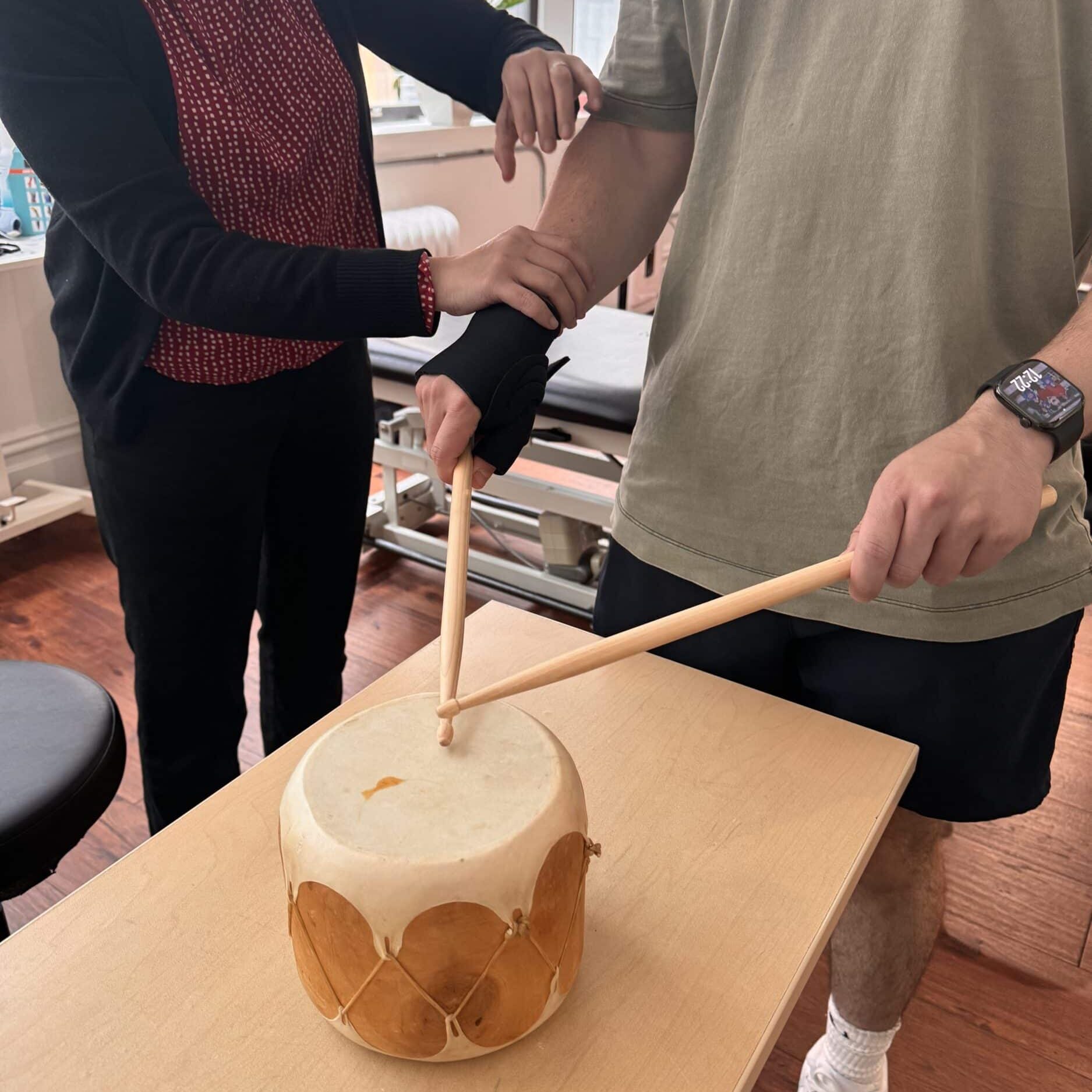 Shereen Tan PT CHT working with her patient, a drummer